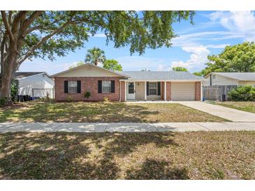 Charming single-story home with a brick facade, lush lawn, and mature shade tree in a quiet neighborhood at 110 Rabun Ct, Sanford, FL 32773