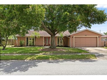 Charming single-story home featuring a well-maintained lawn, mature shade tree, and attached two-car garage at 119 Glendale Dr, Longwood, FL 32750