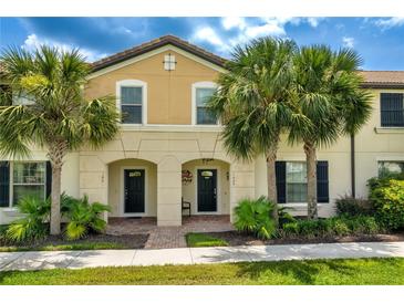 Charming townhouse exterior featuring a well-maintained facade and tropical landscaping with palm trees at 1909 Majorca Dr, Kissimmee, FL 34747