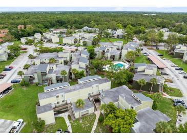 Scenic aerial view of community featuring mature trees and a refreshing neighborhood pool at 208 Scottsdale Sq # 208, Winter Park, FL 32792
