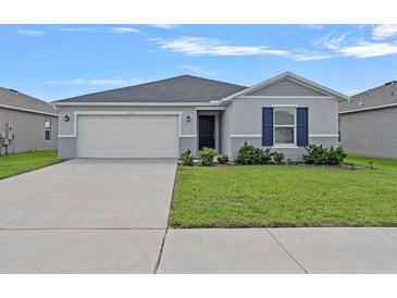 Charming single-story home featuring a two-car garage and a well-maintained lawn at 232 Summerlin Loop, Haines City, FL 33844