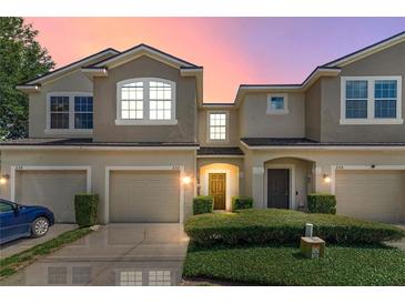 Townhouse exterior features a two-story design with attached garages and manicured landscaping at 232 Windflower Way, Oviedo, FL 32765