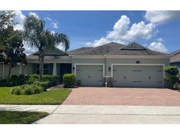 Charming single-story home with a two-car garage, landscaped yard, and a brick driveway at 31961 Redtail Reserve Blvd, Sorrento, FL 32776