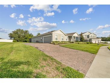Beautiful home with brick driveway and well-maintained landscaping and large green yard at 730 Rominger Loop, Apopka, FL 32712
