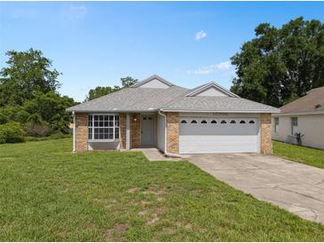 Charming single-story home with brick accents, well-manicured lawn, and attached two car garage at 10708 Brice Ct, Orlando, FL 32817