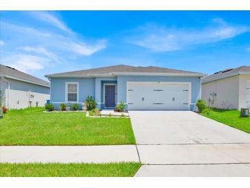 Charming single-story home with a well-maintained lawn and a two-car garage at 145 Piave St, Haines City, FL 33844
