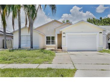 Charming single-story home with a two-car garage and well-maintained exterior, complemented by palm trees at 2742 Woodruff Dr, Orlando, FL 32837