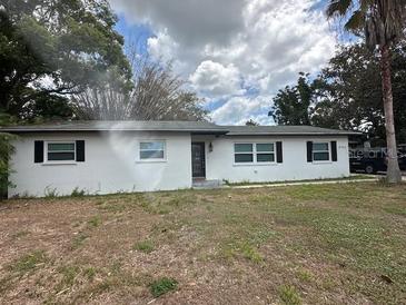 Charming single-Gathering home featuring a classic white facade, black door, and a green lawn at 4732 Luce Rd, Lakeland, FL 33813