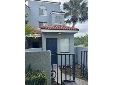 Charming two-story townhome featuring a private front entrance with a well-maintained garden and walkway at 4741 Chevy Pl # 149C2L, Orlando, FL 32811