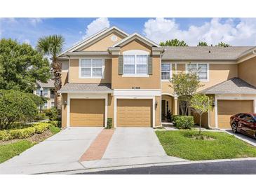 Inviting townhouse featuring a well-manicured lawn and private garages at 6388 Castelven Dr # 102, Orlando, FL 32835