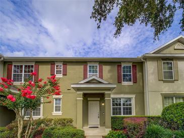 Charming townhome featuring red shutters, a well manicured front yard, and a welcoming entrance at 7462 Bentonshire Ave, Windermere, FL 34786
