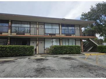Two-story exterior showing balconies, walkway and parking, on a sunny day at 7900 S Orange Blossom Trl, Orlando, FL 32809