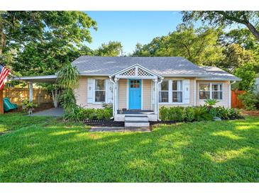 Charming single-story home with a bright blue front door, lush lawn, and covered carport at 815 E 11Th Ave, Mount Dora, FL 32757