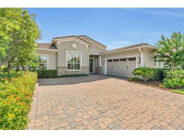 Charming single-Gathering home showcases lush landscaping and a brick paver driveway at 13232 Alderley Dr, Orlando, FL 32832