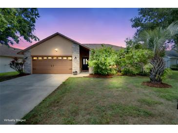Charming single-Gathering home featuring a two-car garage and a beautifully landscaped front yard at 2406 Sweetwater Blvd, St Cloud, FL 34772