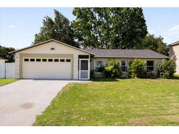 Charming single-story home with a well-maintained lawn and attached two-car garage at 303 Mariana Way, Kissimmee, FL 34758