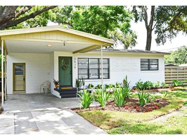 Charming single-story home with a quaint, landscaped front yard and a welcoming covered entrance with an olive colored front door at 3519 Amigos Ave, Orlando, FL 32808