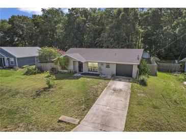 Charming single-story home featuring a well-maintained lawn and a long driveway leading to an attached garage at 3565 Sw Idlewild St, Dunnellon, FL 34431