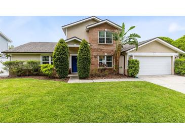 Charming two-story home with brick accents, manicured lawn, and a blue front door at 4478 Yachtmans Ct, Orlando, FL 32812