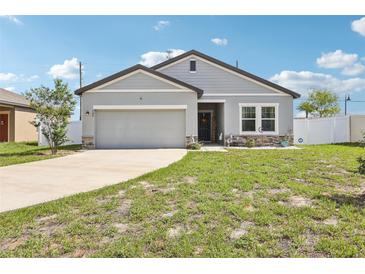 Charming one-story home with a well-manicured lawn, attached garage, and neutral-colored exterior at 785 Orchid Grove Blvd, Davenport, FL 33837