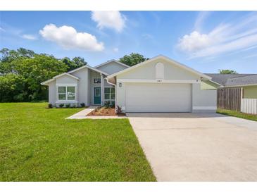 Charming single-story home featuring a well-manicured lawn, a two-car garage, and a welcoming blue front door at 841 Wesson Ct, Casselberry, FL 32707