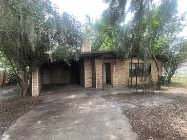 Charming home featuring a unique stone facade and inviting driveway, surrounded by lush trees at 4250 Lake Ave, Kissimmee, FL 34746