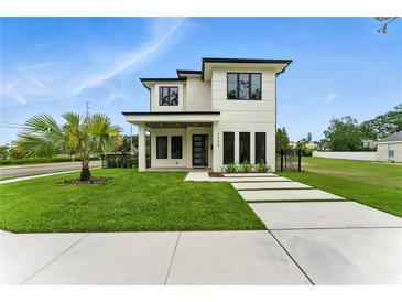 Modern two-story home with a well-manicured lawn, minimalist landscaping, and contrasting dark trim at 1733 Harmon Ave, Winter Park, FL 32789
