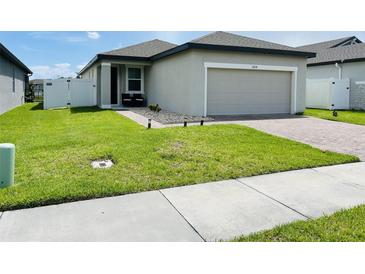Charming single-story home features an attached garage and well-maintained lawn at 2824 Neverland Dr, New Smyrna Beach, FL 32168