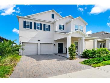 Charming two-story home featuring a two-car garage, blue shutters, and a brick driveway at 4908 Lotta Ct, St Cloud, FL 34772