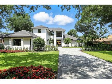 Stunning two-story home featuring manicured lawn, vibrant flower beds and a paved driveway leading to the grand entrance at 5074 Isleworth Country Club Dr, Windermere, FL 34786