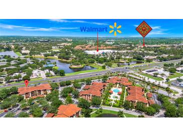 Aerial view of the condo community with a lush landscape, lake, and close proximity to Walmart at 5566 Metrowest Blvd # 10, Orlando, FL 32811