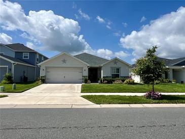 Charming single-story home with a two-car garage, beautiful lawn, and landscaped garden at 7 Polermo Ave, St Cloud, FL 34771