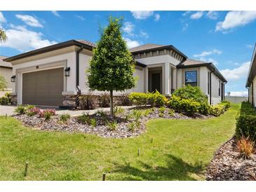 Well-manicured front yard of a modern home featuring lush green grass and carefully arranged landscaping at 971 Braewood Dr, Clermont, FL 34715