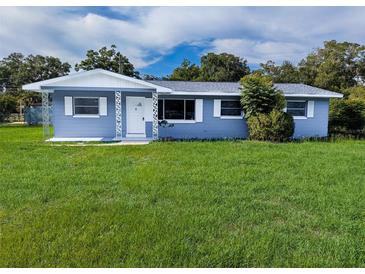 Charming one-story home with a freshly painted exterior, a well-manicured lawn, and decorative trim at 1200 Ne 45Th Pl, Ocala, FL 34479