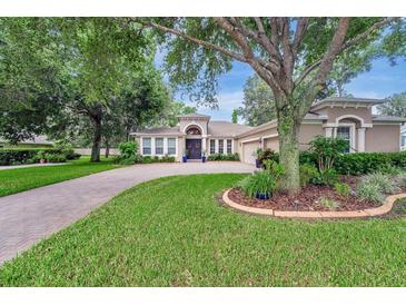 Charming home featuring a brick driveway, well-manicured lawn and mature trees at 2579 Woodside Ridge Dr, Apopka, FL 32712