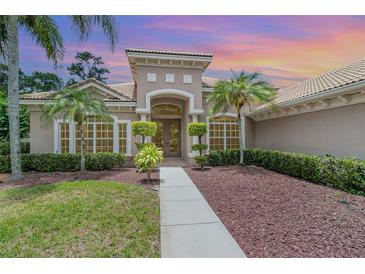 Beautiful home exterior with lush landscaping, palm trees, and inviting front entry at sunset at 336 Highcroft Ct, Lake Mary, FL 32746