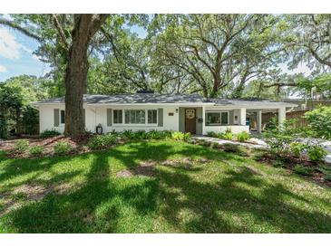 Charming single-story home featuring a well-manicured lawn and a welcoming facade with mature trees in front at 610 Kittredge Dr, Orlando, FL 32805