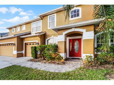 Charming two-story home with a well-maintained front yard and inviting red front door at 7621 Brightwater Pl, Oviedo, FL 32765