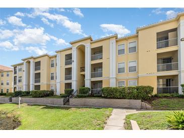 Well-maintained condo building with lush landscaping and multiple balconies under a partly cloudy sky at 1125 Lake Shadow Cir # 5308, Maitland, FL 32751