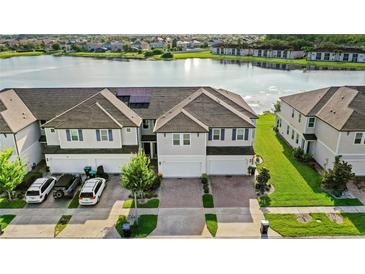 Beautiful multi-Gathering home overlooking a serene lake featuring a brick driveway and solar panels at 15577 Willow Arbor Cir, Orlando, FL 32824