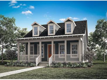 Charming cottage-style home featuring a welcoming front porch and three dormer windows, complemented by lush landscaping at 1993 Beach Ter, Celebration, FL 34747