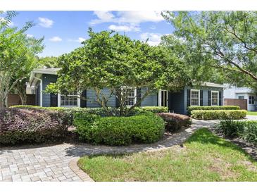 Charming single-story home featuring professional landscaping with mature trees and a brick walkway leading to the entrance at 2312 S Summerlin Ave, Orlando, FL 32806