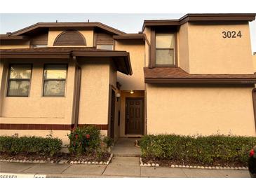 Beige two-story home with a well-manicured lawn and front door at 3024 S Semoran Blvd # 7, Orlando, FL 32822