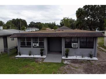 Charming one-story home featuring gray paint, window security bars, and landscaping at 4204 Columbia St, Orlando, FL 32811