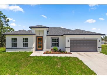A charming single-story home with a well-maintained lawn and a gray two-car garage at 6421 Sw 151St Loop, Ocala, FL 34473