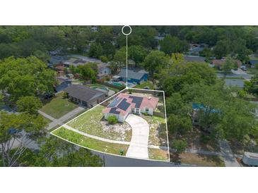 Expansive aerial view of a well-maintained home featuring solar panels and surrounded by lush greenery at 811 Osceola Trl, Casselberry, FL 32707