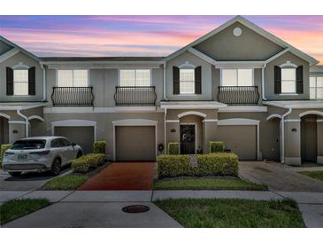 Charming townhome with a well-manicured lawn and inviting front entrance and single car garages at 1191 Honey Blossom Dr # D, Orlando, FL 32824