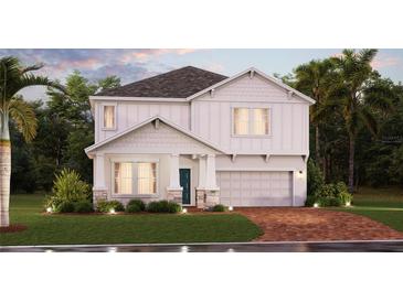 Charming two-story home featuring a manicured lawn, a two car garage, and a welcoming front porch at 2525 Peace Of Mind Ave, Kissimmee, FL 34744