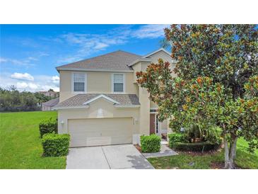 Charming two-story home with a well-maintained lawn and a tree in the front yard at 2669 Manesty Ln, Kissimmee, FL 34747