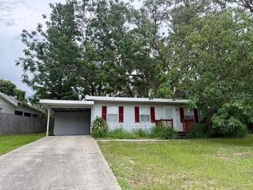 Charming single-story home featuring a carport and a well-maintained front yard at 31538 Anderson Dr, Tavares, FL 32778